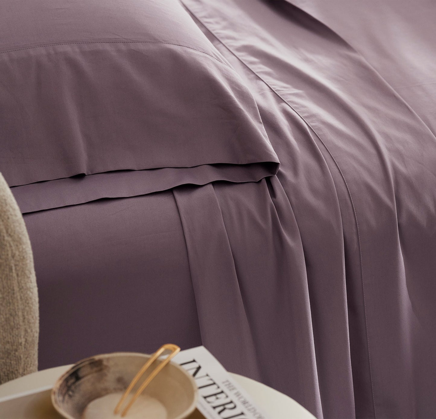 Detail image of bed made with Signature Hemmed Sheet Set in Plum